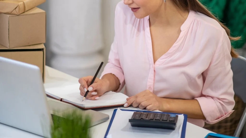 Nice Young Woman Noting Down Her Expenses