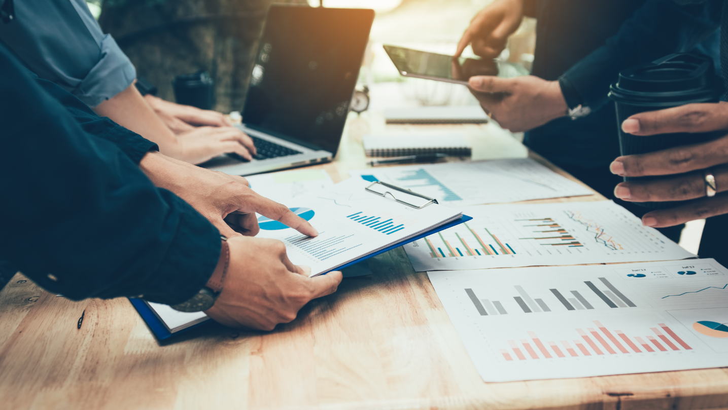 Teamwork With Business People Analysis Cost Graph On Desk At Meeting Room