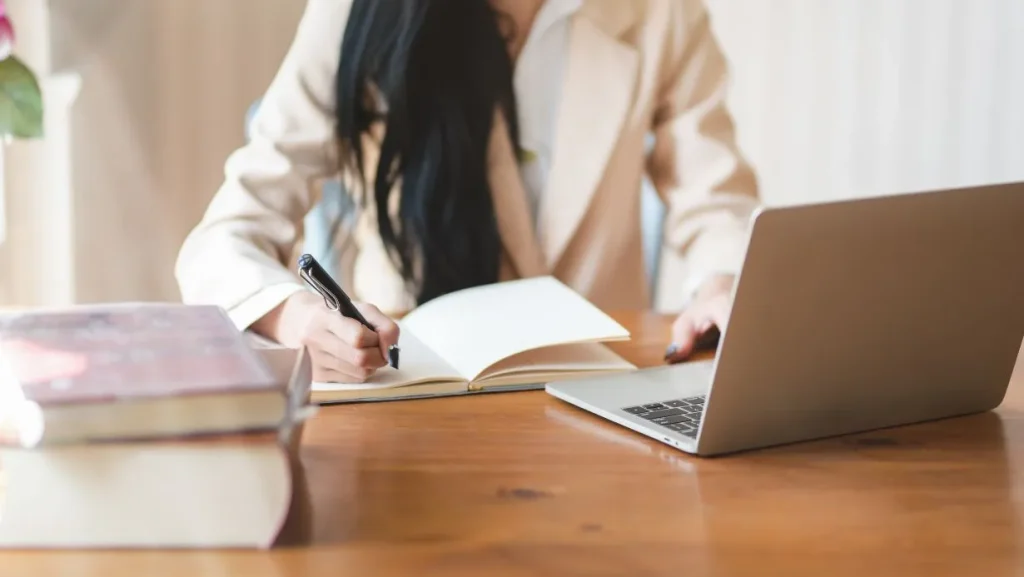 Woman Writing On Notebook 1024x577