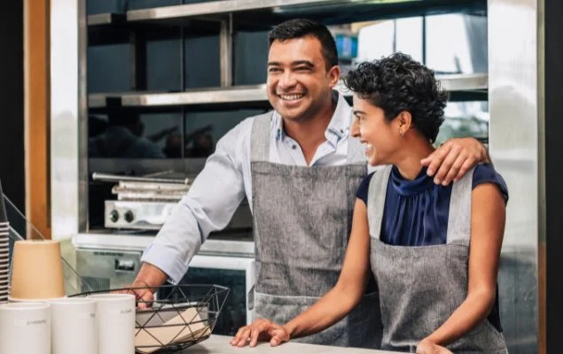 Happy Small Business Owners At Their Cafe